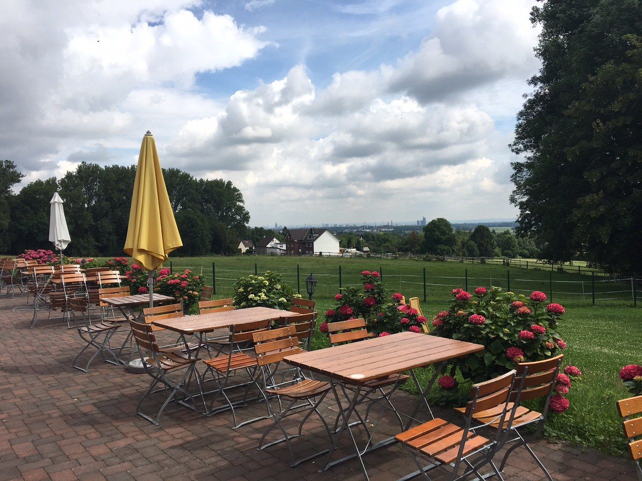 Terrasse des Weilerhofs mit Blick über die Wiesen bis zur Skyline und zum Kölner Dom